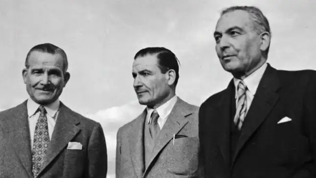 Black-and-white portrait of three of the Maserati brothers in suits and ties against the sky